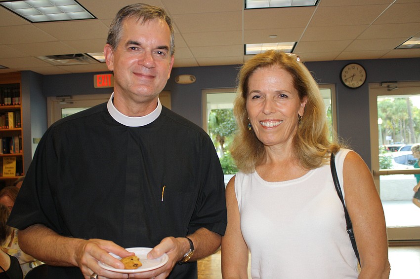 Rev. Lance Wallace talks to Gail Marsdon during the wine and cheese reception following Church of the Redeemerâ€™s service.