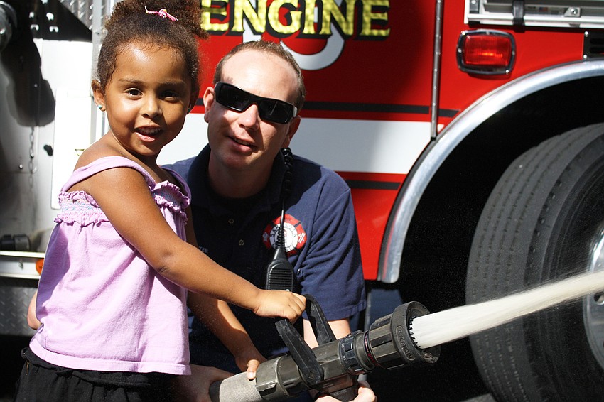 Francesca Magnotti demonstrates how she would put out a fire while firefighterPaul Leverone holds the hose.