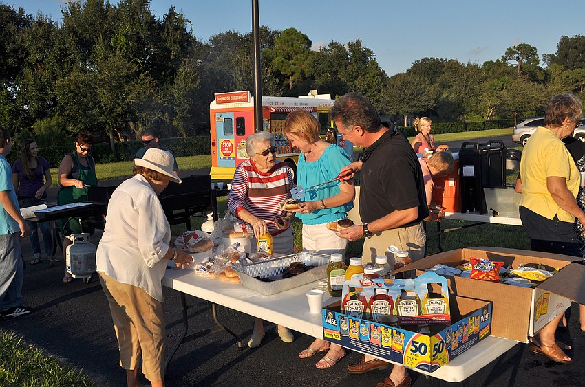 People get hotdogs and burgers Friday, Sept. 30, during of Our Lady of Mount Carmel's pet blessing ceremony.