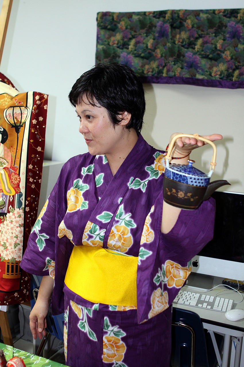 Mayuko Seto holds up a teapot and talks about green tea.