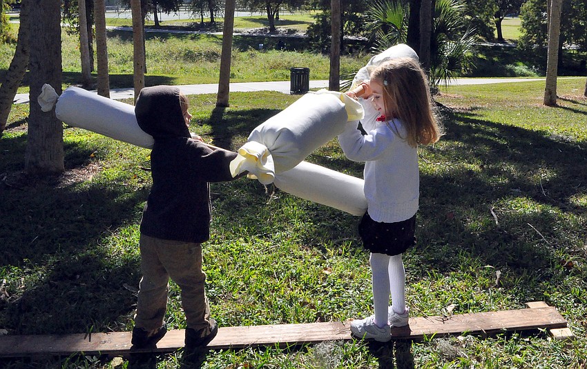 Mason, 3, and Maya, 5, Peters have fun playing an old-fashioned game in the backyard of the Bidwell-Wood house during Pioneer Day.