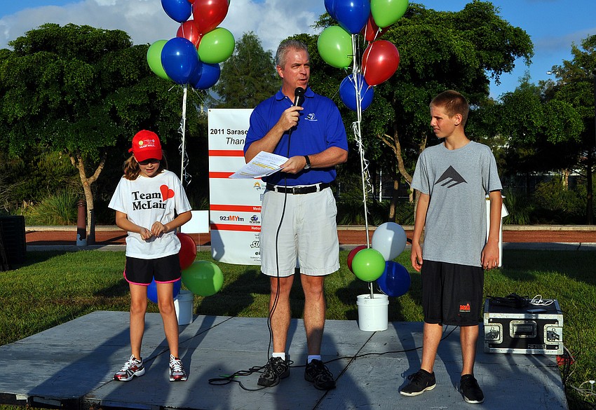 McLain Miller, 10, and Jacob Brockoff, 14, stand on stage as the Subway Kids, one of the main sponsors of the walk, while ABC 7â€™s Scott Dennis talks to the crowd.