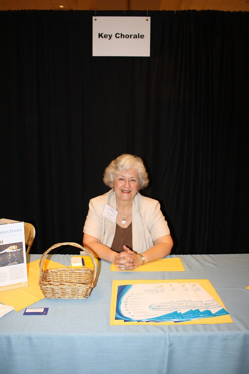 Development Assistant for Key Chorale Peggy Olsen poses in front of her booth.
