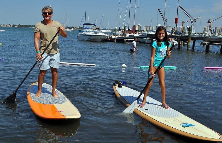 Steve and Kristina, 11, Wieder try out some paddleboards in the shallow water.