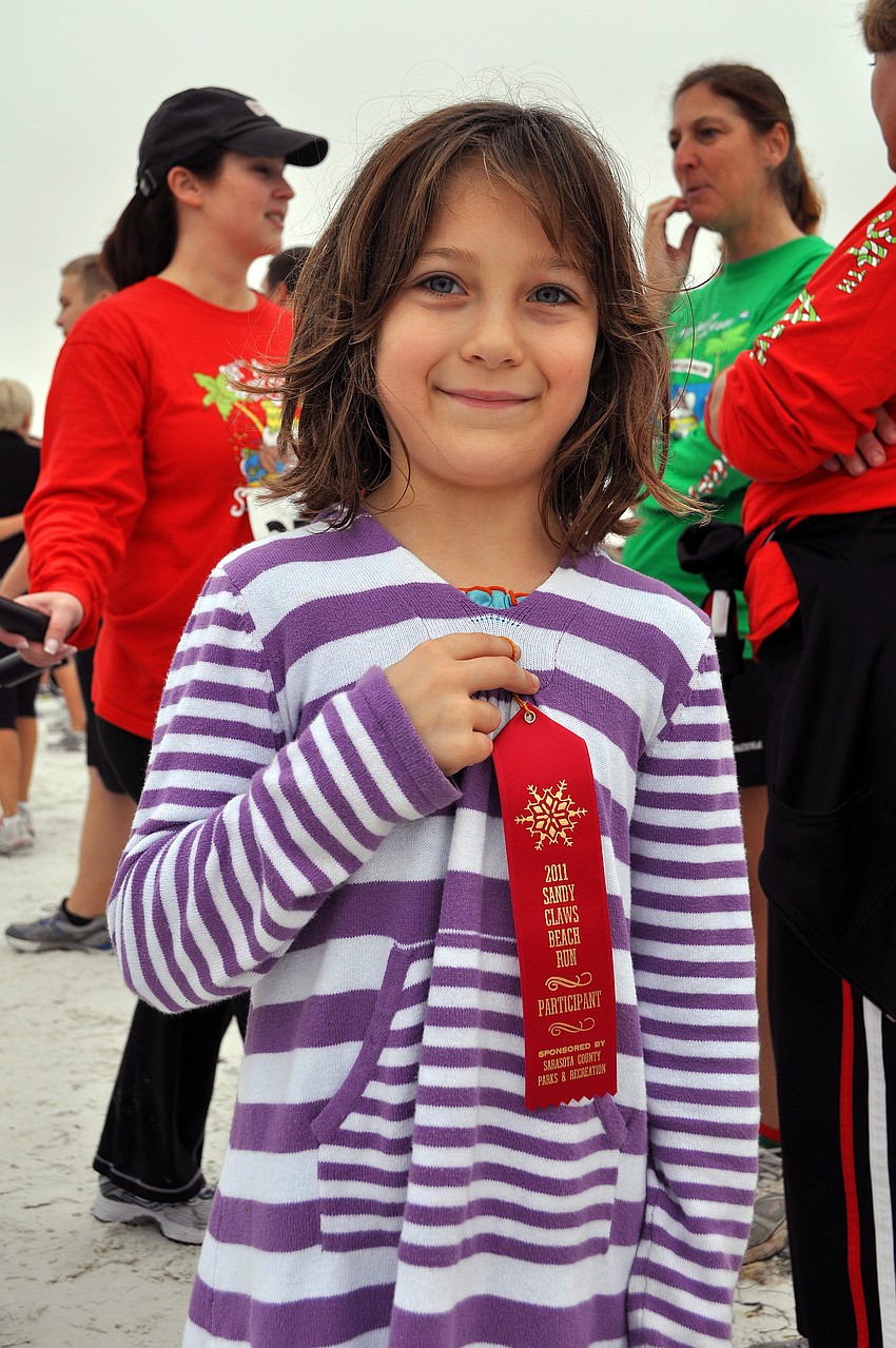 Maelin Bloom, 7, shows off the ribbon she got for completing the 1-mile fun run.