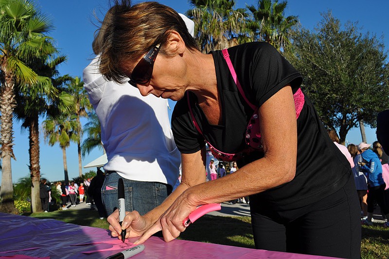 Karen Renda puts the name of a friend on the Wall of Hope.