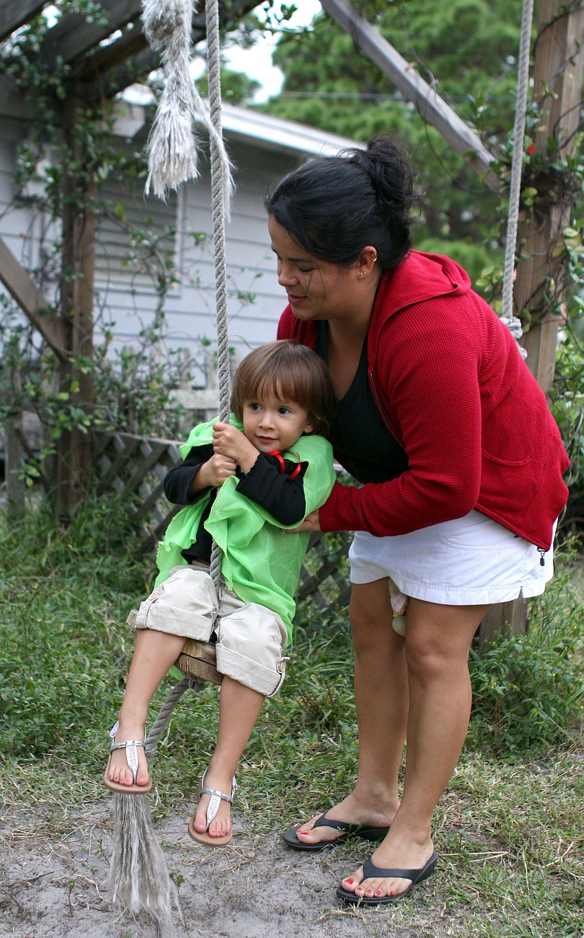 Carolina Procel pushes her daughter, Anabel, 3, on a swing.