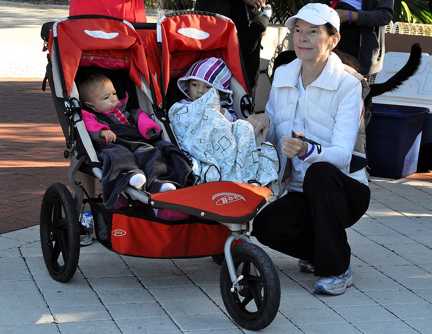 Diane Fritschle, far left, squats down next to her granddaughters, Diana, 1, and Hailey, 3. Fritschle is a 2-year survivor of pancreatic cancer and had to be wheeled across the Ringling bridge in a wheelchair last year.