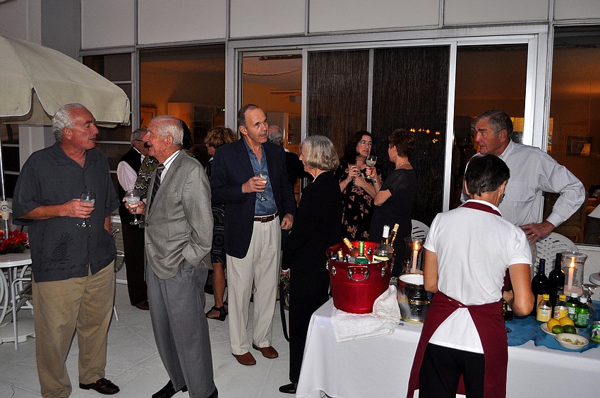 People enjoy having drinks and chatting outside during Ursula Pearson's birthday party at Sands Point.