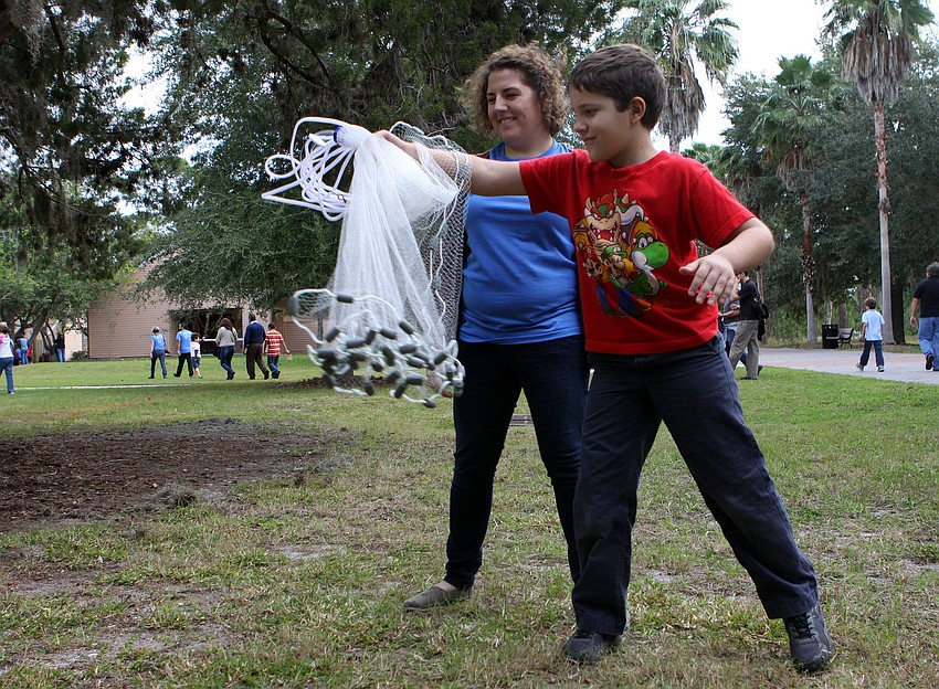 Liz Usherwood watches as Anondrej Smith, 9, tries to throw a net to catch some 