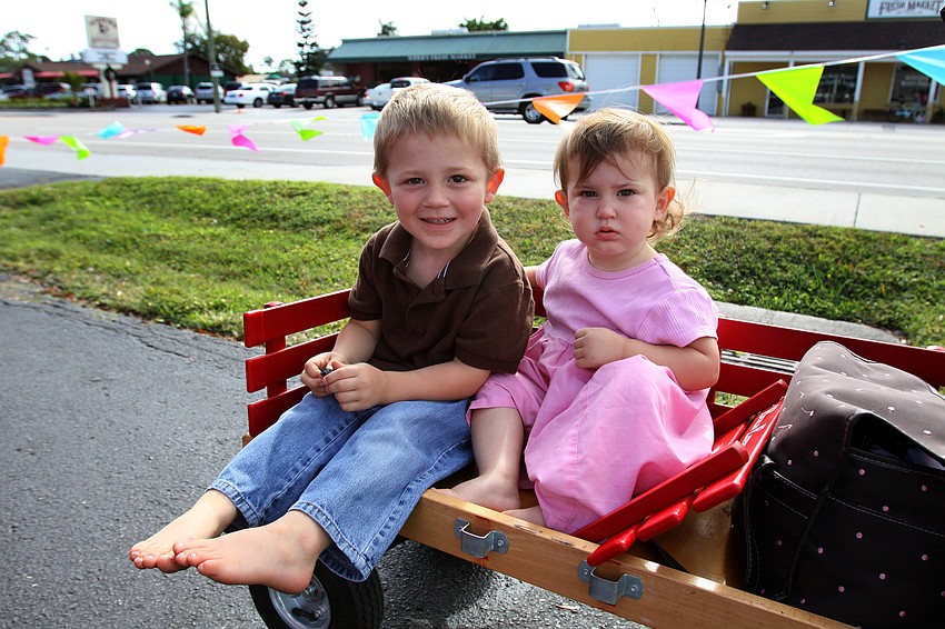 Caleb, 3, and Jerusha, 1 Â½, Yoder sit in their little red wagon.