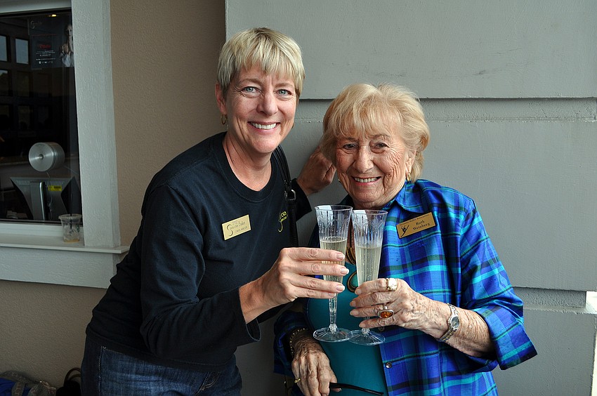 Carol Arscott and Ruth Weinberg hold glasses of champagne as part of the celebration for the Sarasota Ballet dancers returning from Washington, D.C.