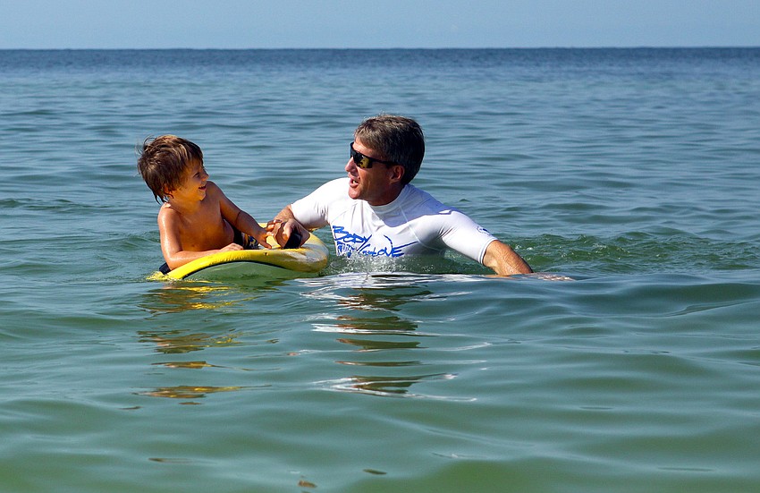Aiden Seymour, 4 Â½, talks with his surf guide, Dan Runyo, before taking another wave during the Hang Ten for Autism surf event Saturday, Sept. 17, at the Siesta Key Public Beach.