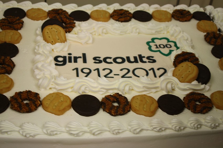 The Girl Scouts of the Gulf Coast of Florida celebrate the 100 years of Girl Scouts with a cake full of Girl Scout cookies.