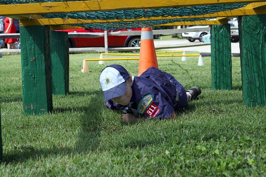 Russell Aetomu, 8, from Pack 11 of the Boy Scouts, tries his best to make his way under one of the obstacles in the Sarasota County SWAT teamâ€™s obstacle course that was set up following the Remembrance March Sunday, Sept. 11, at Payne Park.