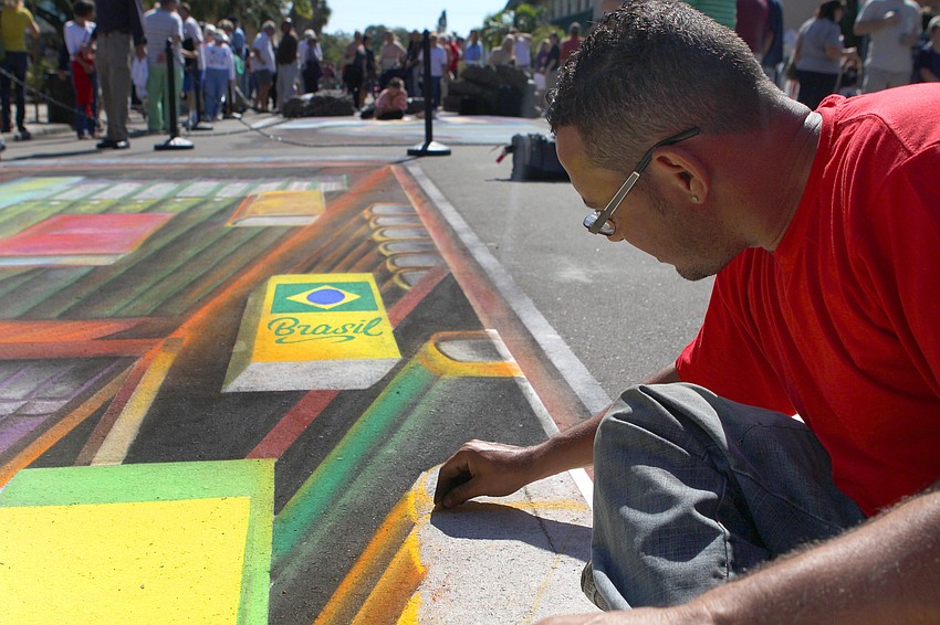 Marcos Rafael of Sao Paulo, Brazil, works on his 3D piece of a boy reading among hundreds of books.