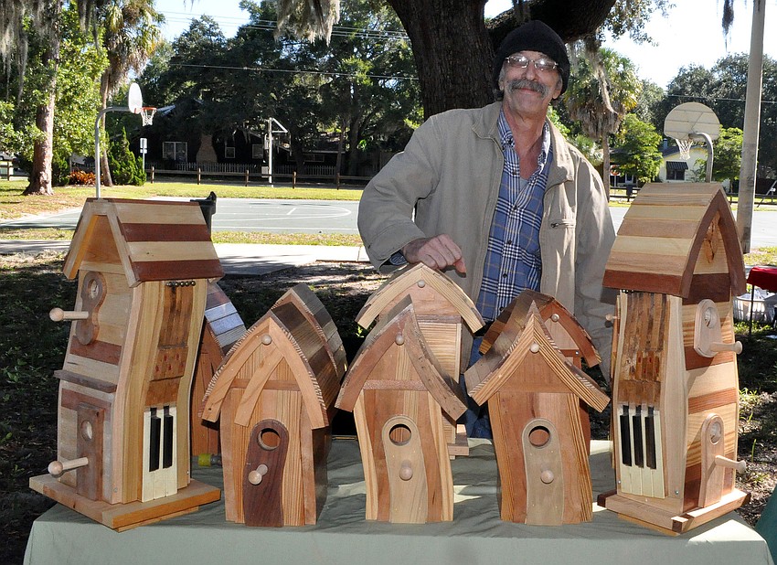 Sam Steward, owner of Sawdust Sam's, poses with his bird houses.