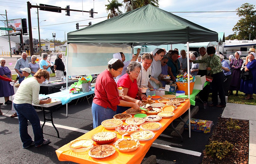 People line up to get their servings of chili and a piece of pie.