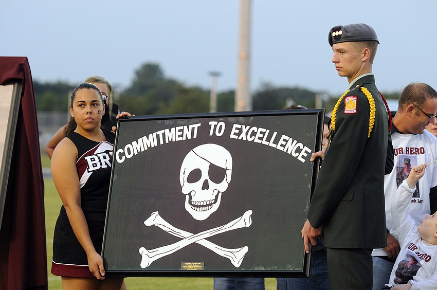 Braden River High seniors Laura Otiza and Billy Heller presented U.S. Army Spc. 4 Patrick Lay IIâ€™s family with an honorary Pirate flag.