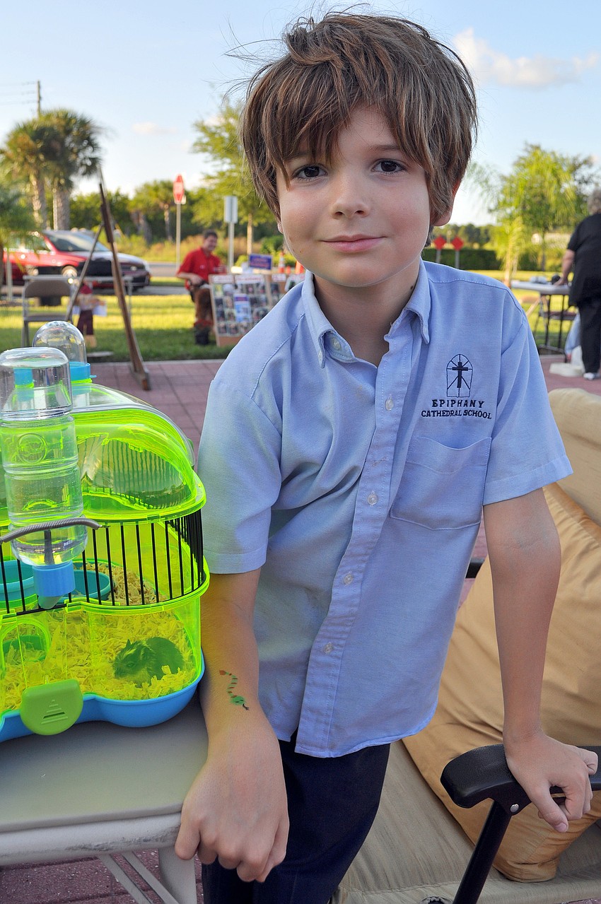 Michael Riembauer, 7, poses with his snake arm painting and his pet gerbil, Tron.