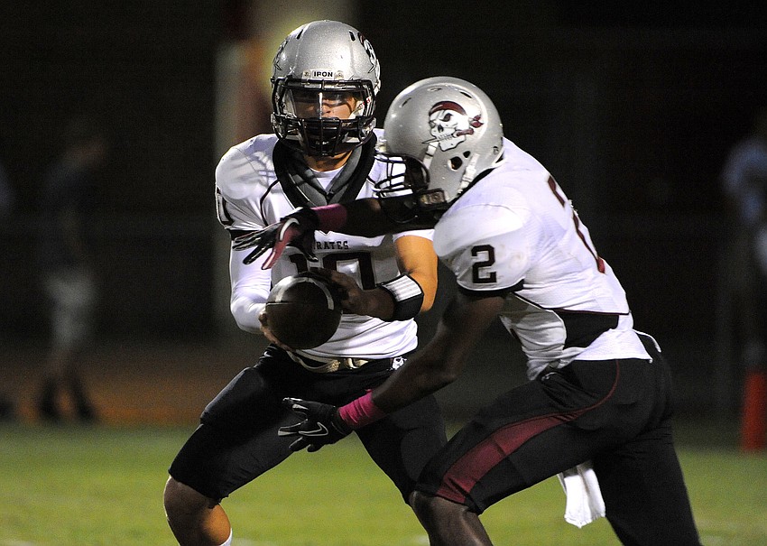 Braden River quarterback Ryan Fischer hands the ball off to tailback Demond Brantley.