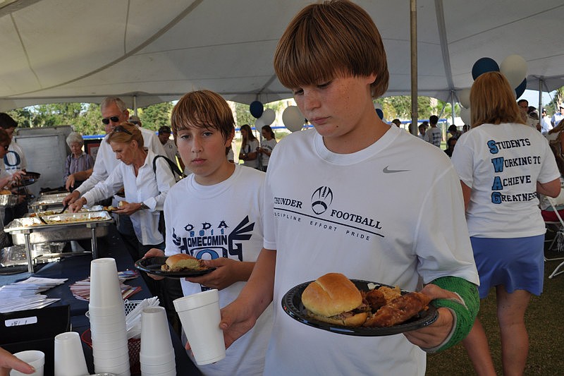 Twelve-year-old Brad Hansel, front, fills up his plate with food catered by Lee Roy Selmon's Restaurant and the Guerilla Chef during the pre-game picnic.