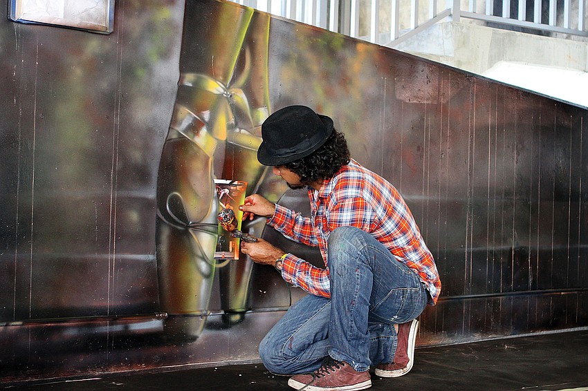Eduardo Kobra, from Sao Paulo, Brazil, works on some finishing touches to ballet slippers that he and his team from StudioÂ KobraÂ created on the second-floor walls.