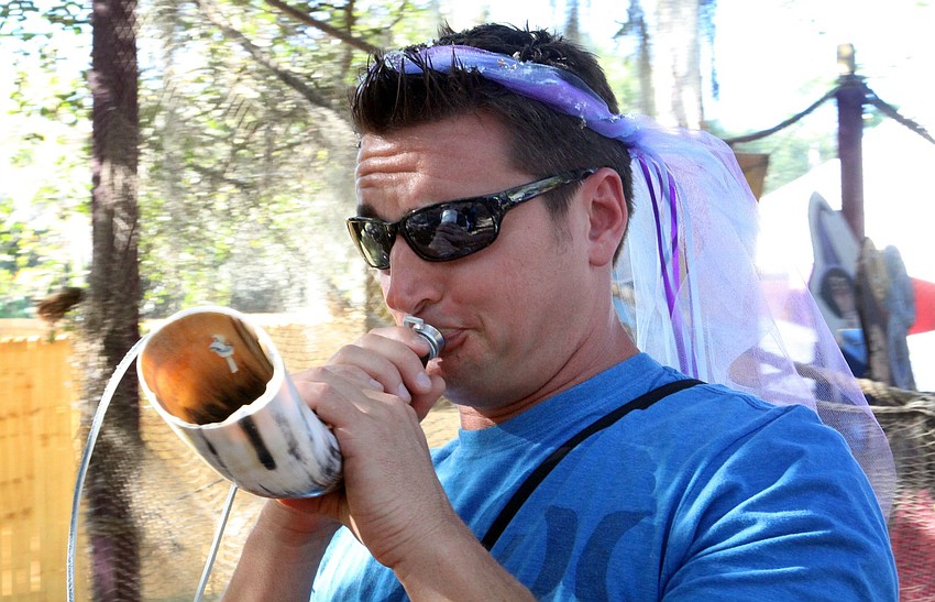 Jason Moore tries to blow through the bull horn, but fails during his attempt.