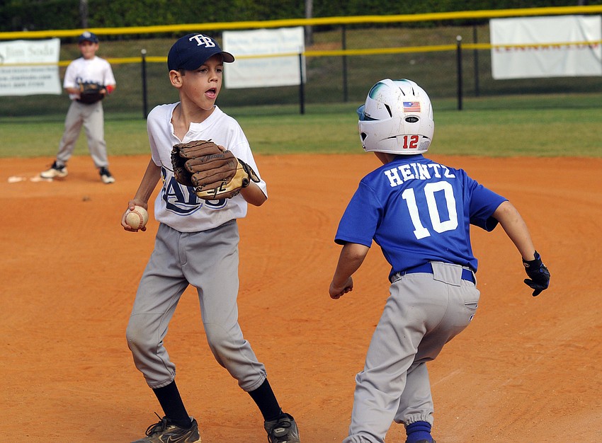 The Cubsâ€™ Alex Heintz tries to get avoid second-grader Jaden Stocktonâ€™s tag and get safely back to first base.