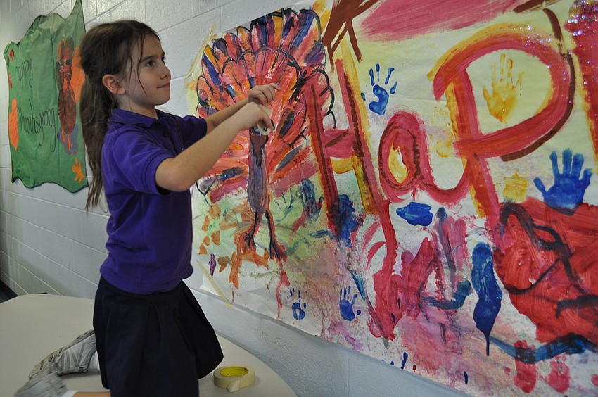 Eden Glickman helps secure a banner to the wall of the Salvation Army.