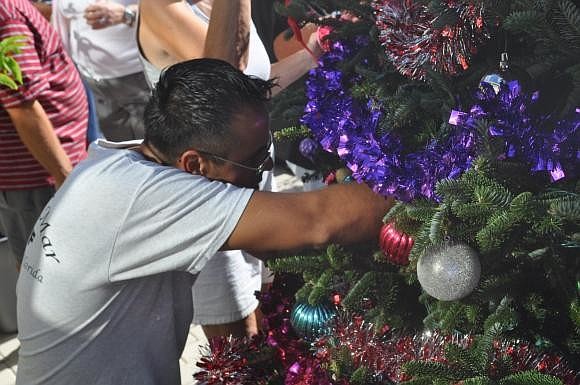 Elton Arellano decorates the Casa Del Mar Christmas tree. Photo by Mallory Gnaegy.