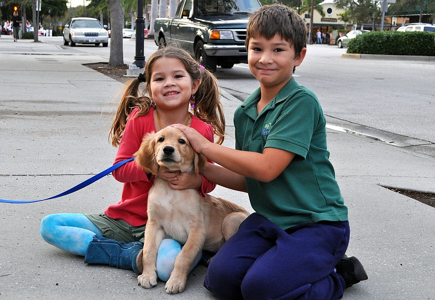 Lauren, 6, and Evan, 8, pose with their early Christmas gift, Cooper.