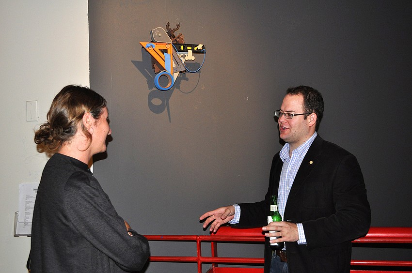 Nathan Skiles talks to Kim Anderson during the opening of THIRTEEN, Friday, Dec. 9, at G Wiz.