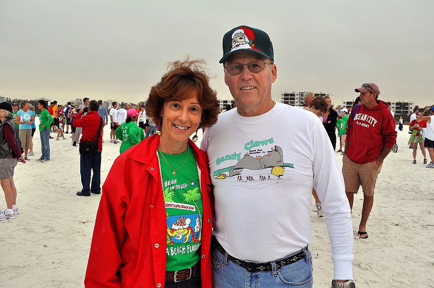 Director of Parks and Recreation, Carolyn Brown, poses with the first director, Walt Rothebach, Saturday, Dec. 10, at the 35th annual Sandy Claws run on Siesta Key Beach.