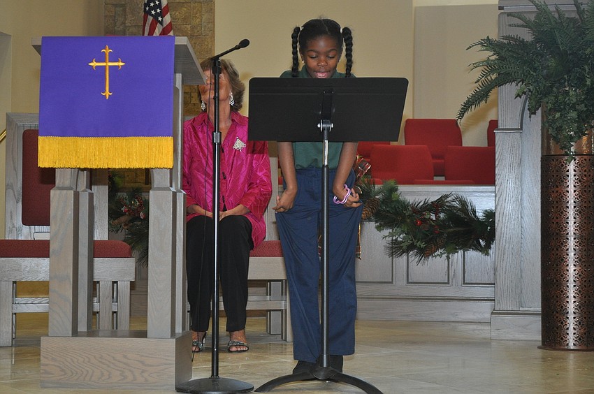 Yazmine Anderson reads to the congregation
