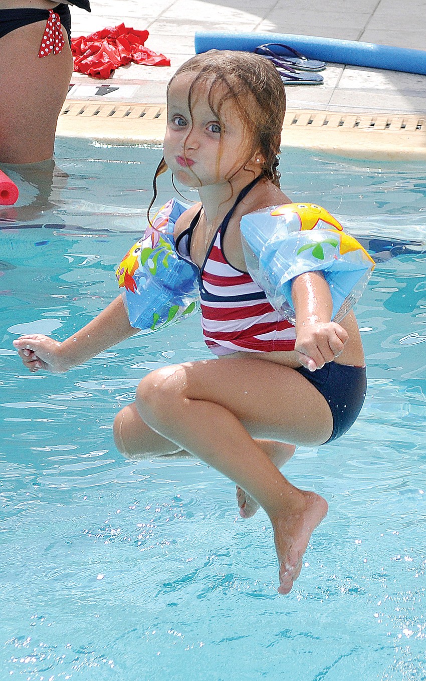 Naomi Cassagnol hangs above the water before splashing into the pool at Sarasota Yacht Clubâ€™s Fourth of July celebration.