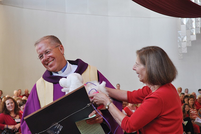 The Rev. Don Henry receives gifts from Sister Judy Baldino in March at a celebration honoring Henryâ€™s 10th year as priest of St. Thomas More Catholic Church and his 40th year as a priest.