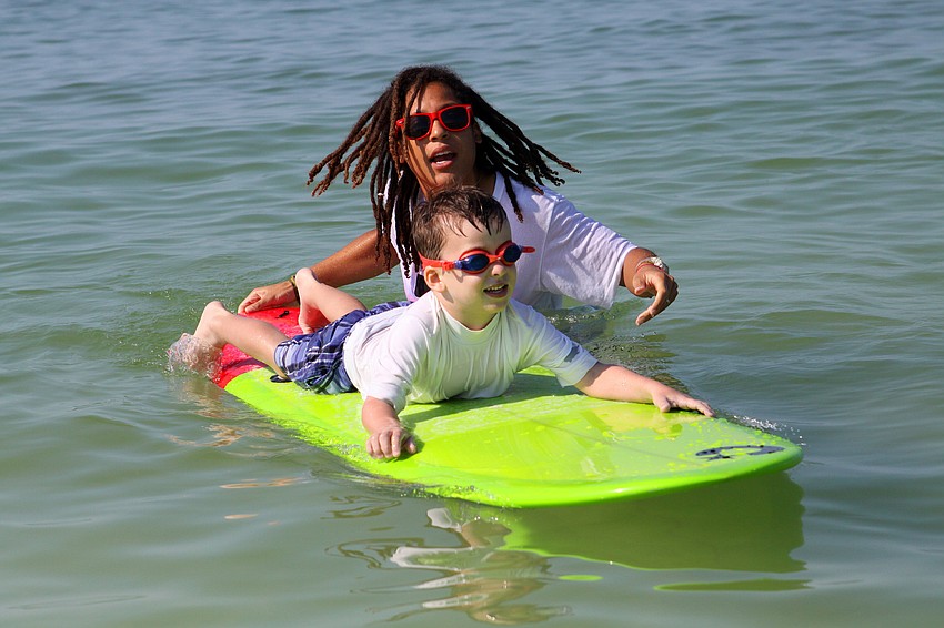 Amber Yoder gives Evan Crowe, 4, a big push Saturday, Sept. 17, during the Hang Ten for Autism surf event at the Siesta Key Public Beach.