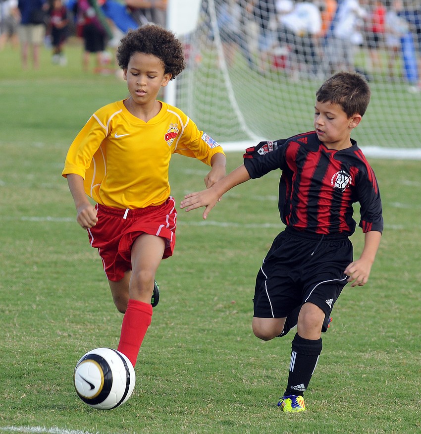 Sean Scharmer of the Clearwater Chargersâ€™ U9 team tries to bring the ball up the field past the Boynton Beach Nightsâ€™ Bradley Espinosa.