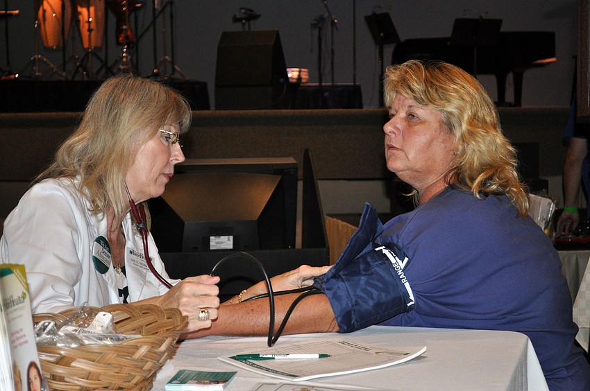 Florida Home Healthâ€™s Dee King checks Kimberly Copelandâ€™s blood pressure.