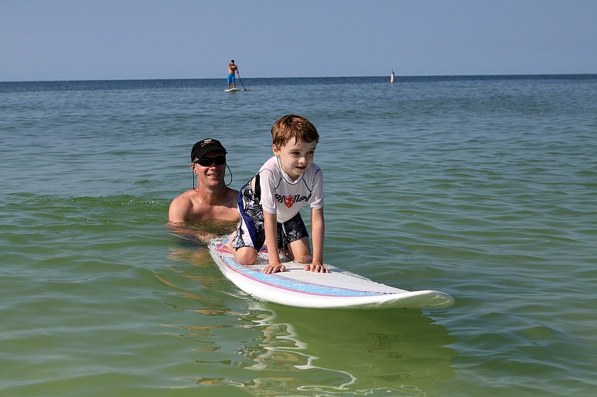 Kurt Hemmel gives his son, Ethan, 6, a push during the Hang Ten for Autism surf event Saturday, Sept. 17, at the Siesta Key Public Beach.