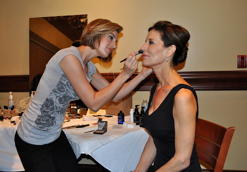 April Piana of Cutting Loose Salon and Spa applies the finishing touches to fashion show model, Penny Hill.
