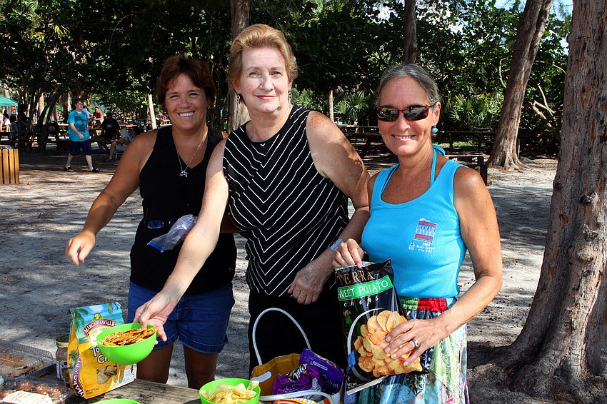 Kathy Olson, Anne Curran and Joni Luckenbill set out some of the food for the potluck.