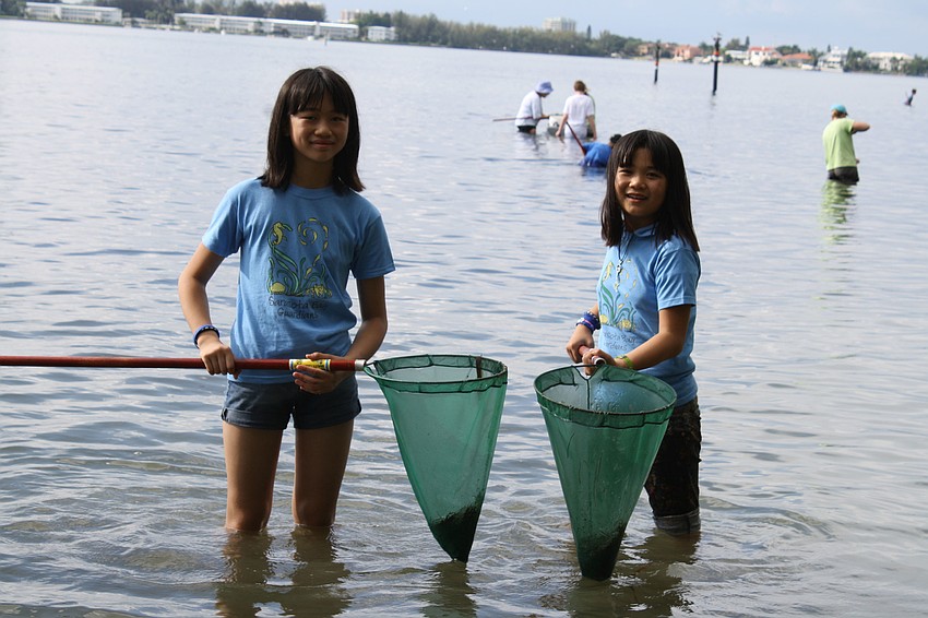Sisters Vanessa and Michelle Kwak get up-and-personal with marine life in the bay by dip netting.