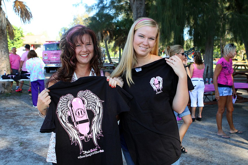 Janine Bernard and Mandy Mann show off the shirts they bought from some of the firefighters involved in the Pink Heals campaign.