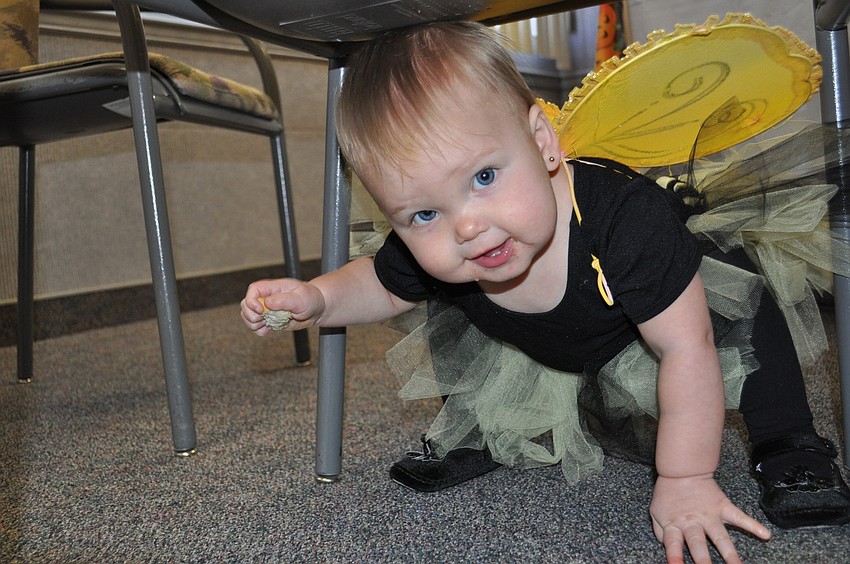 Julie McCollum peeks under a chair.