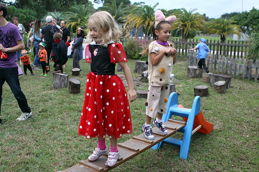 Cami Culver, 6, and Fiona Sutton, 5, jumped around in the play garden while they wait to go on the tour through the fairy tale world, Sunday, Oct. 30, at Pine Shores Presbyterian.