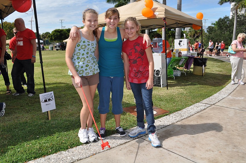 Hannah, Zoe and Angelica hang with Rosco, a 4-month-old golden retriever puppy dressed as a witch.
