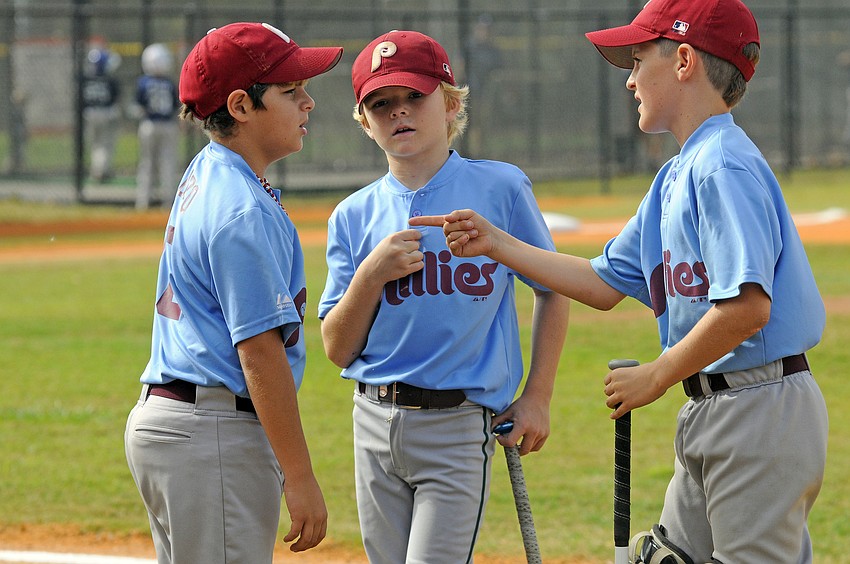 Kevin Alonzo, 9, Trent Hedgepeth, 8, and Calvin Chapman, 10, go over their game plan before the start of the Minors division championship game Nov. 19.