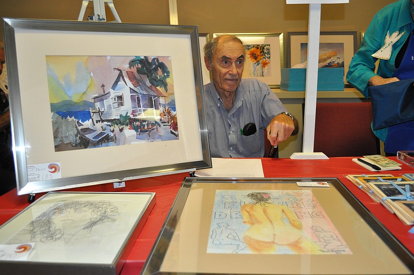 Paul Hehre sits behind his original artwork